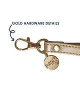 Gold hardware details on wristlet detachable strap.