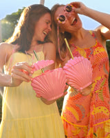 Girls wearing summer dresses and flower sunglasses holding beach shell shaped novelty cups