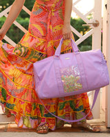 woman holding duffle travel weekend bag confetti and purple
