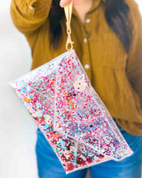 Girl holding up a clear clutch by its handle