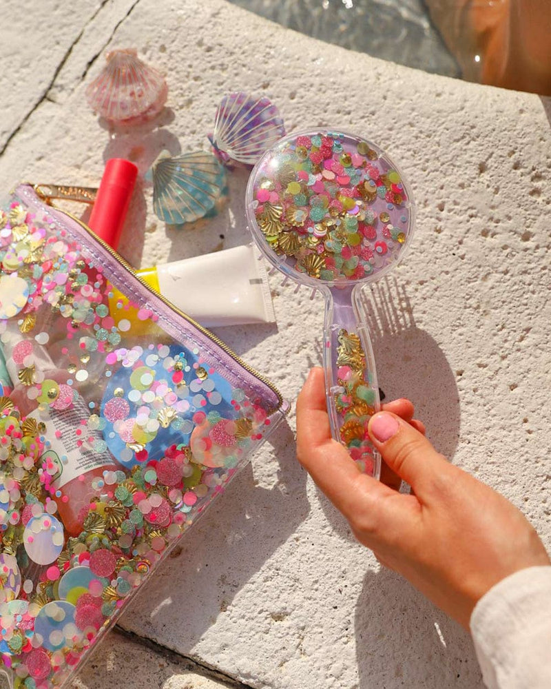 girl holding confetti hairbrush with confetti products