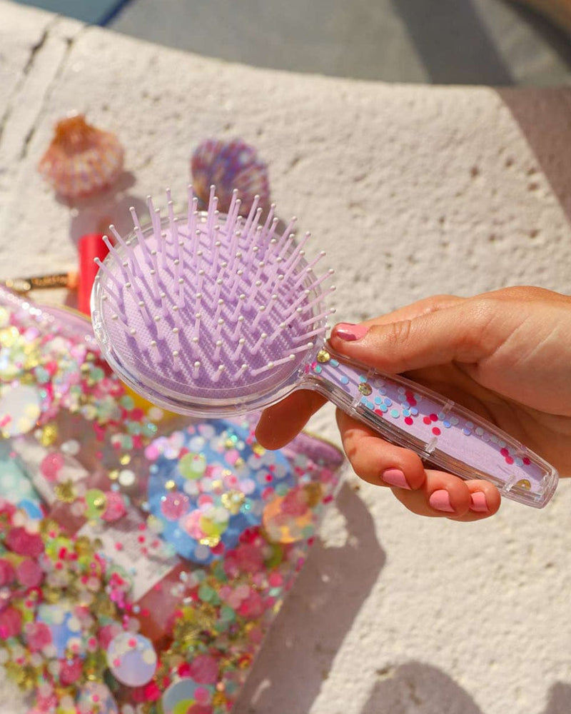 girl holding confetti hairbrush with confetti products