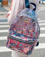 Cute blue backpack with trapped colorful confetti on a lady walking across a street