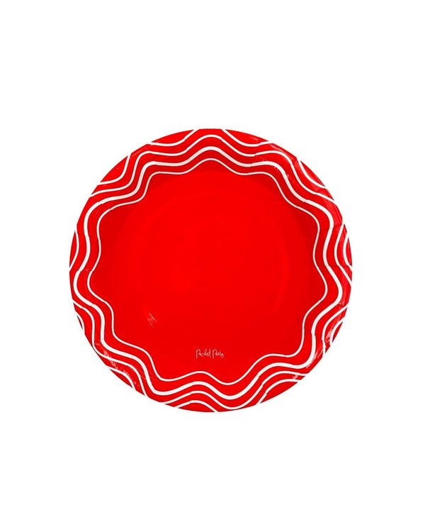 A red circular plate that has white waves along the rim. 