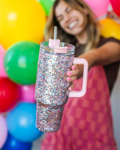 Stainless steel glitter water bottle with pink handle and lid.