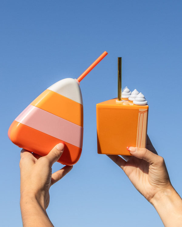 Cheers with candy corn for Halloween and Thanksgiving pumpkin pie sippers up in the sky blue background. 