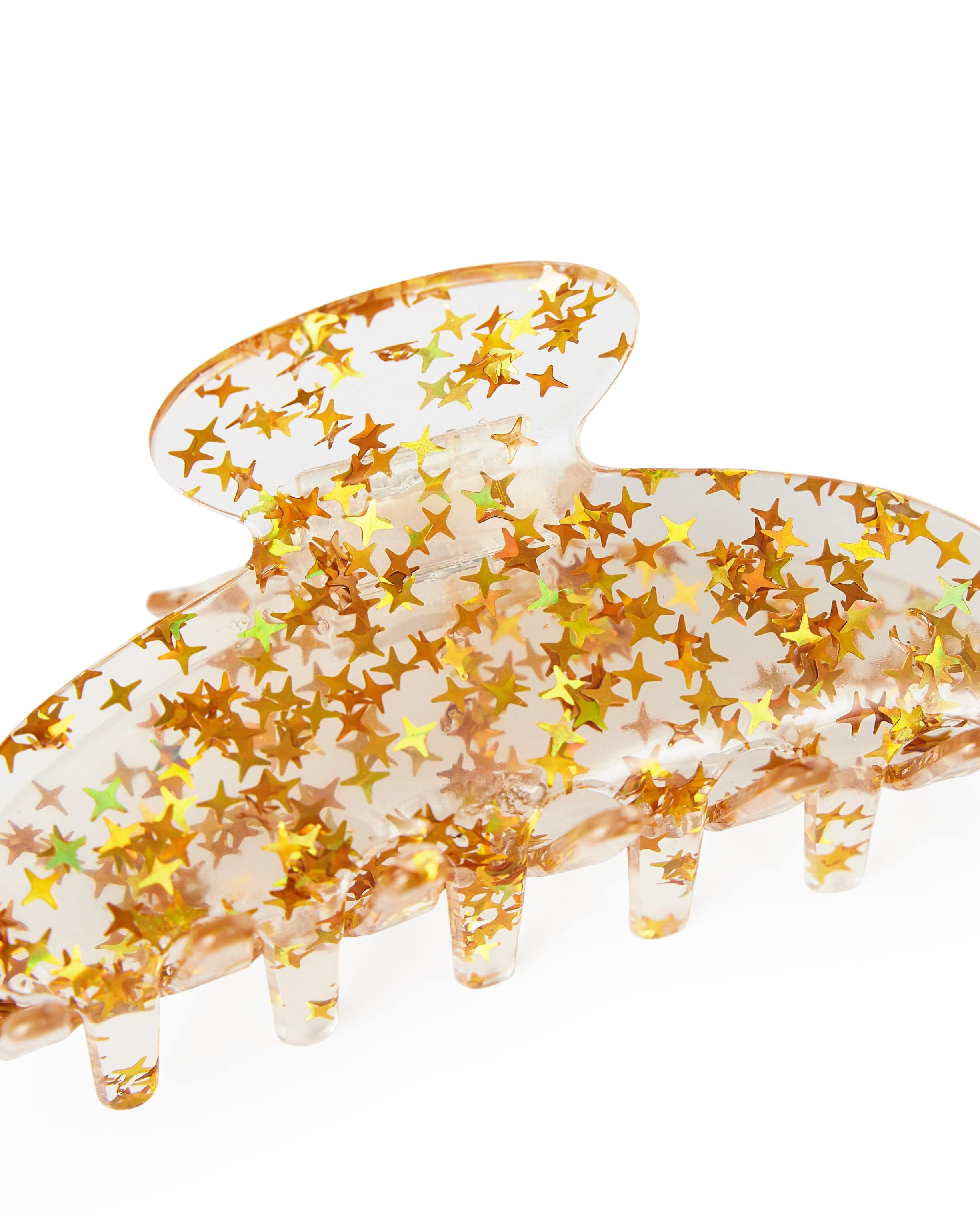 Close up on a clear claw clip filled with gold stars. 