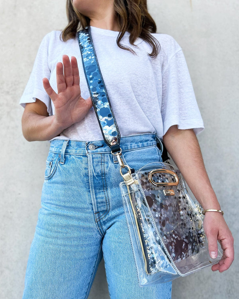 Girl holding confetti purse strap on clear stadium approved bag.