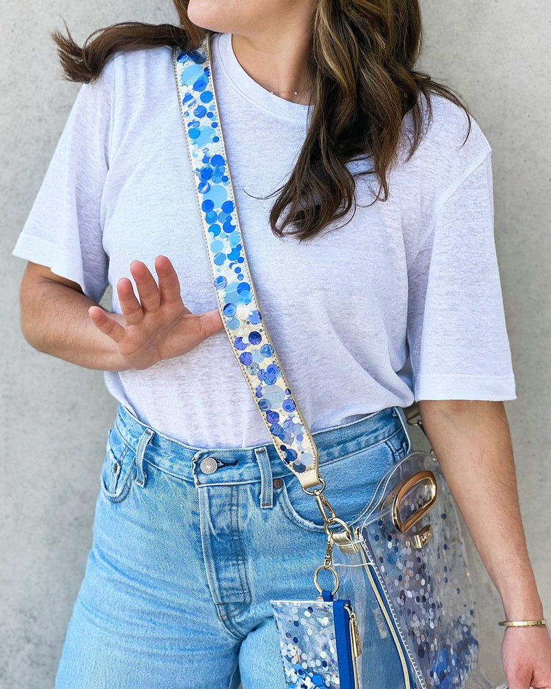 Girl holding confetti purse strap on clear stadium approved bag.