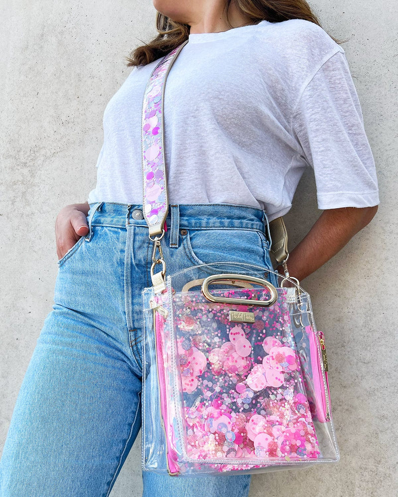 Woman wearing colorful confetti girly cute purse strap and clear bag.
