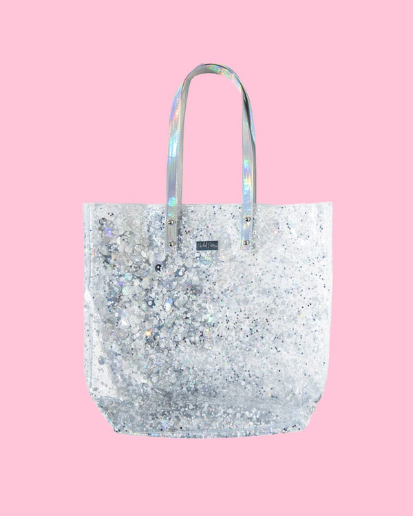 A clear, silver confetti tote bag with iridescent straps. 
