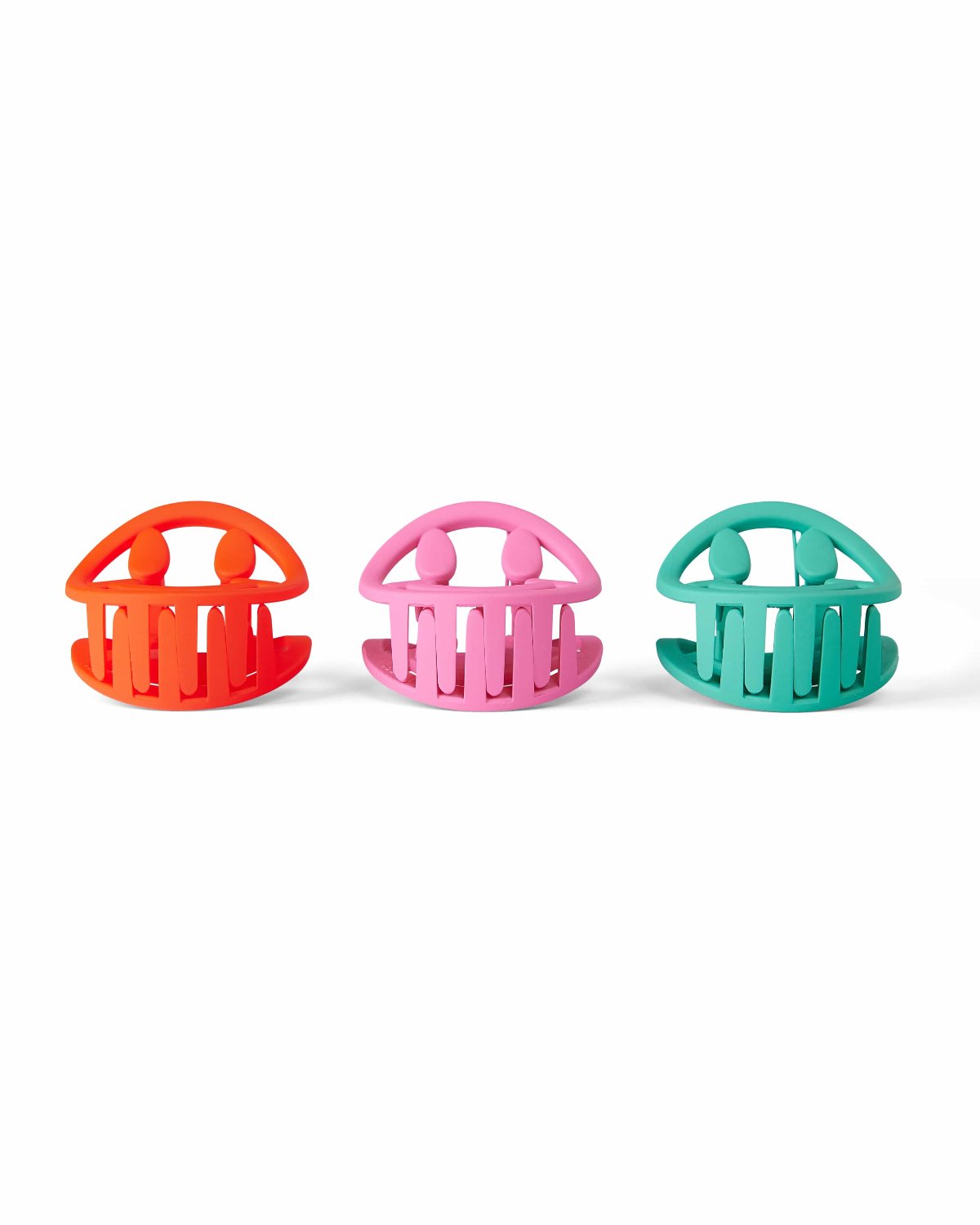 Red, pink, and green smiley claw clip with opening faced upwards shot against white background. 