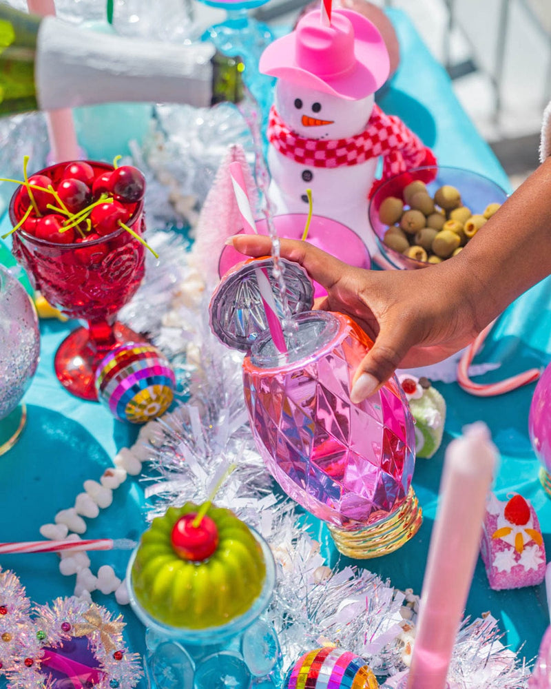 champagne pouring into bright pink vintage light sipper at a colorful holiday party