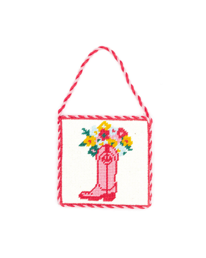 fun needlepoint design of a pink boot with a bouquet of flowers inside