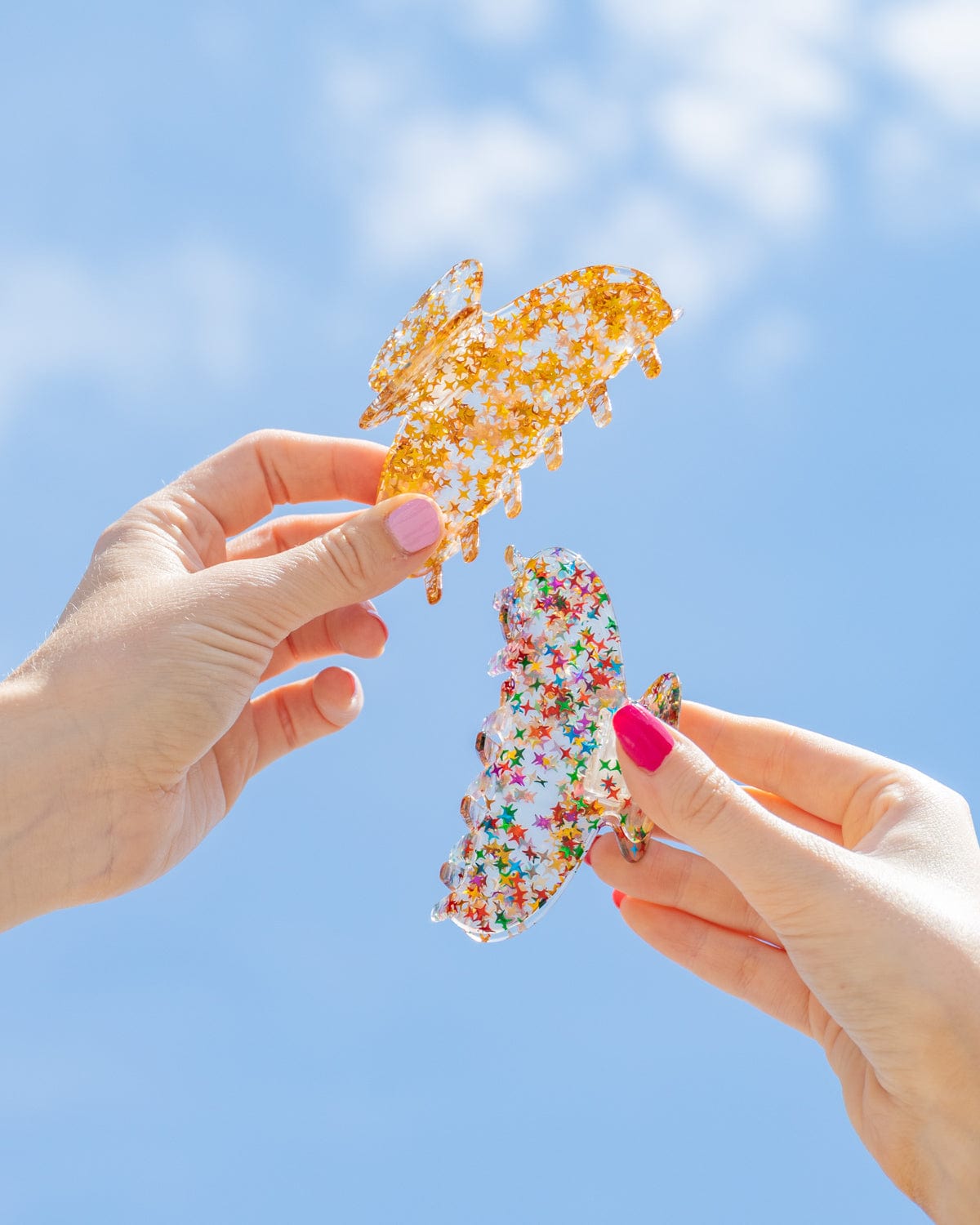 Two people hold the claw clips to the sky. 
