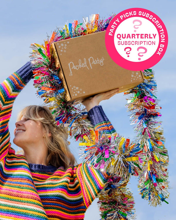 Woman in rainbow sweater holding Packed Party subscription box