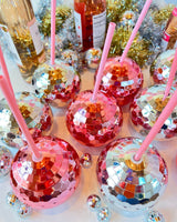 silver and rose gold disco balls together in a party scene with wine and tinsel