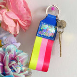 Red, pink, yellow, and blue keychain with confetti.