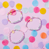 3 Packed Party x LWP project bracelets on a pink table with confetti