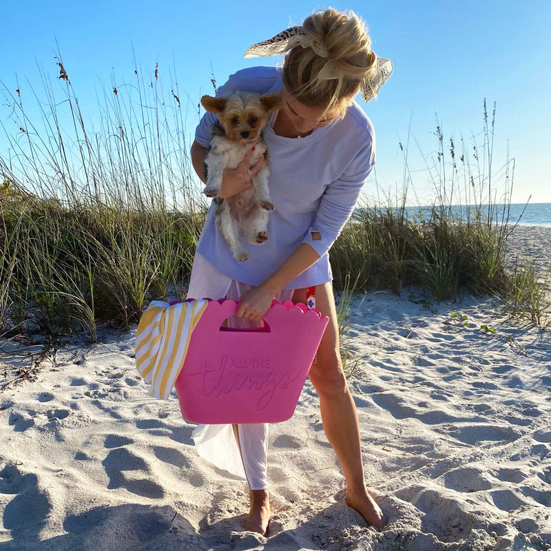 Girl with a puppy on a beach with a pink jelly tote