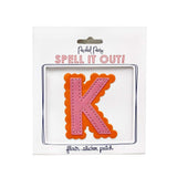 Pink and orange scalloped letter K sticker.