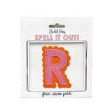 Pink and orange scalloped letter R sticker.